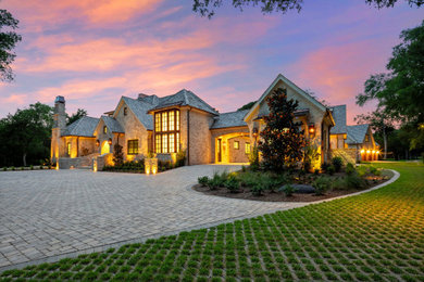 Large french country one-story brick exterior home idea in Austin with a mixed material roof