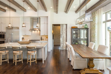 Inspiration for a large transitional l-shaped eat-in kitchen in Austin with an undermount sink, shaker cabinets, white cabinets, quartz benchtops, beige splashback, glass tile splashback, stainless steel appliances, dark hardwood floors, with island and brown floor.
