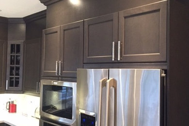 Eat-in kitchen - mid-sized transitional u-shaped marble floor and white floor eat-in kitchen idea in Toronto with an undermount sink, shaker cabinets, black cabinets, granite countertops, metallic backsplash, mosaic tile backsplash, stainless steel appliances and an island