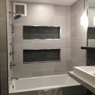 Aménagement d'une salle de bain principale moderne de taille moyenne avec des portes de placard en bois sombre, une baignoire en alcôve, un combiné douche/baignoire, un carrelage noir et blanc, des plaques de verre, un mur blanc, un sol en carrelage de porcelaine, une vasque et un plan de toilette en quartz modifié.