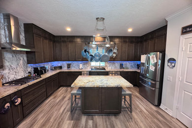Example of a large trendy kitchen design in Houston with a drop-in sink, shaker cabinets, dark wood cabinets, granite countertops, multicolored backsplash, granite backsplash, stainless steel appliances and an island