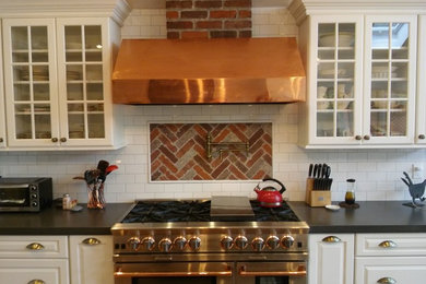 Enclosed kitchen - large traditional single-wall enclosed kitchen idea in New York with raised-panel cabinets, white cabinets, solid surface countertops, red backsplash, brick backsplash, stainless steel appliances and no island