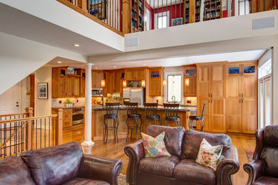 Open concept kitchen - large traditional l-shaped light wood floor open concept kitchen idea in Denver with a double-bowl sink, shaker cabinets, light wood cabinets, granite countertops, brown backsplash, stone tile backsplash, stainless steel appliances and an island
