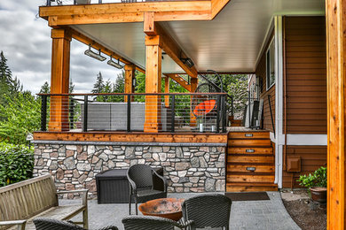 Inspiration for a large modern backyard deck in Seattle with a roof extension.
