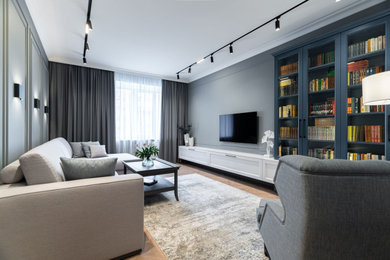 На фото: гостиная комната среднего размера в стиле неоклассика (современная классика) с с книжными шкафами и полками и серыми стенами