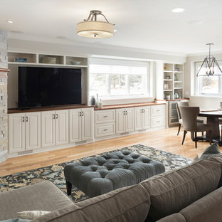 Photo of a medium sized classic look-out basement in Minneapolis with grey walls, light hardwood flooring, a corner fireplace, a stone fireplace surround and brown floors.
