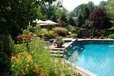 Example of a mid-sized classic backyard concrete paver and custom-shaped lap pool fountain design in New York