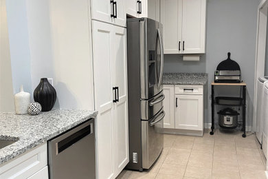 Example of a small classic galley porcelain tile and beige floor kitchen pantry design in Jacksonville with shaker cabinets, white cabinets, granite countertops, stainless steel appliances, a peninsula and gray countertops