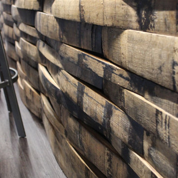 Lower Level Bar With Whiskey Barrel Planks, Gray Cabinets, and Black Quartz