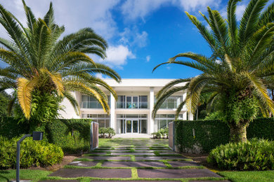 Large modern white two-story concrete exterior home idea in Miami with a green roof