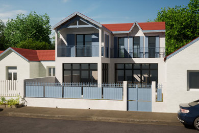 Exemple d'une façade de maison blanche bord de mer de taille moyenne et à un étage avec un toit à deux pans, un toit en tuile et un toit marron.