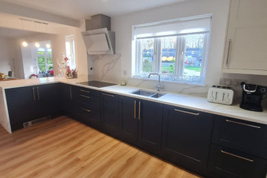 Design ideas for a medium sized classic l-shaped kitchen/diner in Other with a double-bowl sink, shaker cabinets, blue cabinets, quartz worktops, white splashback and white worktops.