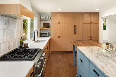 Open concept kitchen - large 1950s u-shaped medium tone wood floor and brown floor open concept kitchen idea in Seattle with an undermount sink, flat-panel cabinets, medium tone wood cabinets, quartzite countertops, multicolored backsplash, porcelain backsplash, stainless steel appliances, an island and multicolored countertops