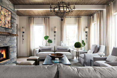 Mountain style medium tone wood floor living room photo in Other with white walls, a standard fireplace and a stone fireplace