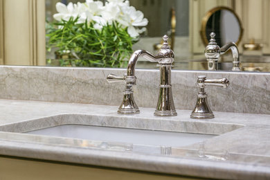 Example of a large transitional master beige tile and marble tile ceramic tile and brown floor double shower design in Seattle with raised-panel cabinets, distressed cabinets, a one-piece toilet, beige walls, an undermount sink, quartzite countertops, a hinged shower door and beige countertops