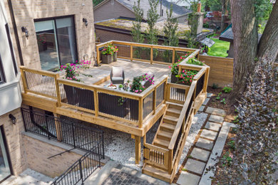 Ejemplo de terraza sin cubierta en patio trasero con barandilla de varios materiales