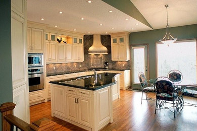 Inspiration for a mid-sized timeless l-shaped ceramic tile and beige floor eat-in kitchen remodel in Calgary with a double-bowl sink, raised-panel cabinets, white cabinets, granite countertops, gray backsplash, ceramic backsplash, stainless steel appliances and an island