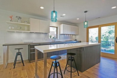 Eat-in kitchen - large modern single-wall medium tone wood floor eat-in kitchen idea in Salt Lake City with an undermount sink, flat-panel cabinets, dark wood cabinets, quartz countertops, white backsplash, ceramic backsplash, stainless steel appliances and an island
