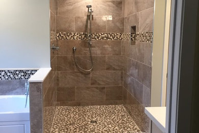 Minimalist glass tile marble floor and brown floor bathroom photo in Houston with raised-panel cabinets, white cabinets, a one-piece toilet, white walls, solid surface countertops, white countertops and an undermount sink
