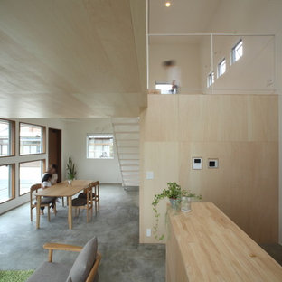 Стильный дизайн: маленькая гостиная-столовая в скандинавском стиле с белыми стенами, бетонным полом и серым полом - последний тренд