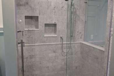 This is an example of a large transitional master bathroom in Bridgeport with gray tile, marble, green walls, porcelain floors, an undermount sink, marble benchtops, grey floor, a sliding shower screen and grey benchtops.
