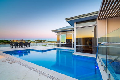 Inspiration for a mid-sized contemporary backyard custom-shaped natural pool in Perth with natural stone pavers.