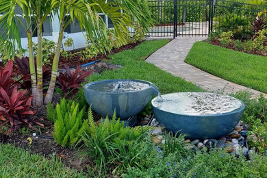 Design ideas for a large tropical full sun side yard brick water fountain landscape in Other.