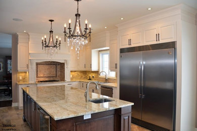 Kitchen - mid-sized transitional l-shaped kitchen idea in Ottawa with raised-panel cabinets, white cabinets, marble countertops, beige backsplash, stone tile backsplash, stainless steel appliances and an island