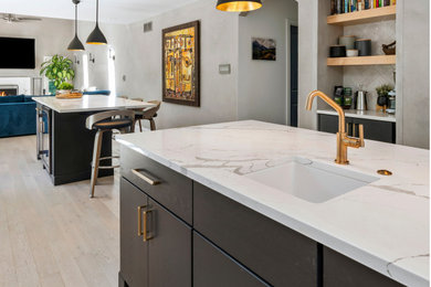 Example of a large minimalist galley light wood floor and beige floor eat-in kitchen design in Philadelphia with a drop-in sink, shaker cabinets, white cabinets, quartz countertops, white backsplash, ceramic backsplash, stainless steel appliances, two islands and white countertops