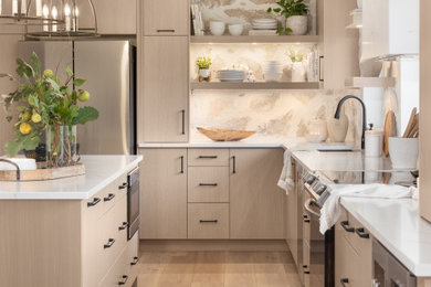 Example of a mid-sized transitional l-shaped vinyl floor and beige floor eat-in kitchen design in Other with an undermount sink, flat-panel cabinets, light wood cabinets, quartz countertops, beige backsplash, stone tile backsplash, stainless steel appliances, an island and white countertops