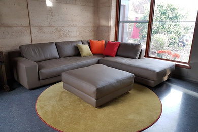 This is an example of a large industrial open concept living room in Adelaide with beige walls and grey floor.