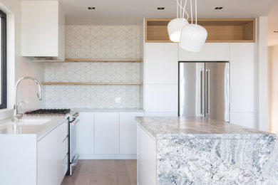 Inspiration for a mid-sized contemporary l-shaped light wood floor and beige floor open concept kitchen remodel in San Francisco with an undermount sink, flat-panel cabinets, white cabinets, white backsplash, stainless steel appliances and an island