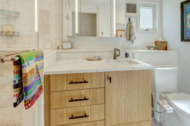 Bathroom - small modern white tile and ceramic tile porcelain tile, multicolored floor and single-sink bathroom idea in New York with flat-panel cabinets, light wood cabinets, a bidet, white walls, an undermount sink, quartz countertops, a hinged shower door, white countertops and a built-in vanity