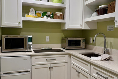 Example of a transitional medium tone wood floor and vaulted ceiling kitchen design in Nashville with an undermount sink, recessed-panel cabinets, white cabinets, quartz countertops and white countertops