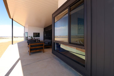 Mid-sized modern one-storey house exterior in Other with metal siding, a metal roof and a black roof.