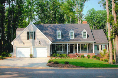 Example of a yellow two-story wood gable roof design in Other