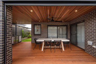 Design ideas for a mid-sized contemporary backyard and ground level deck in Canberra - Queanbeyan with a pergola.