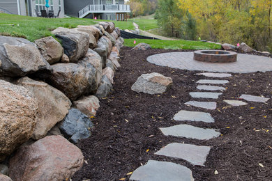 Example of a small mountain style backyard concrete paver patio design in Minneapolis with a fire pit and no cover