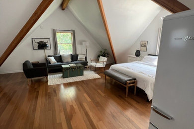 Ejemplo de dormitorio clásico con paredes blancas, suelo de madera en tonos medios, suelo marrón y vigas vistas