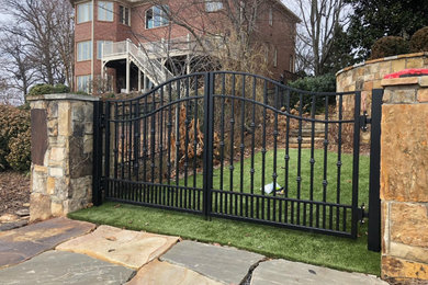 ナッシュビルにある広いトラディショナルスタイルのおしゃれな前庭 (門扉、日向、天然石敷き、樹脂フェンス) の写真