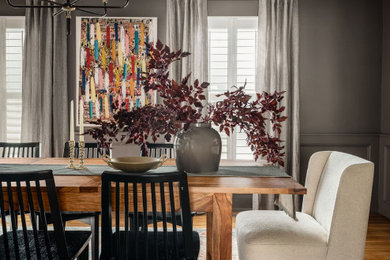Example of a mid-sized transitional medium tone wood floor, brown floor and wainscoting kitchen/dining room combo design in DC Metro with gray walls