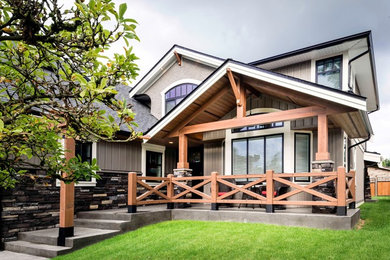 Example of a large beige two-story mixed siding exterior home design in Vancouver with a hip roof