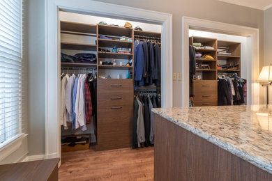 Inspiration for a large contemporary gender-neutral dressing room in Minneapolis with flat-panel cabinets, medium wood cabinets and medium hardwood floors.
