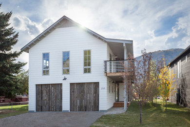 Photo of a mid-sized country two-storey white exterior in Jackson with wood siding and a gable roof.