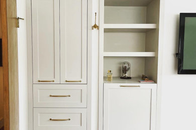 Example of a large transitional gender-neutral built-in closet design in Denver with shaker cabinets and beige cabinets
