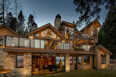 Inspiration for a large rustic brown three-story stone gable roof remodel in Sacramento