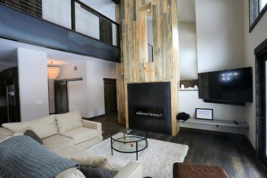 Inspiration for a mid-sized modern open concept dark wood floor living room remodel in Other with white walls, a standard fireplace, a wood fireplace surround and a wall-mounted tv