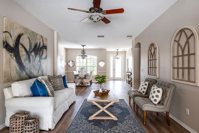 Tuscan formal and open concept dark wood floor living room photo in Orlando with beige walls and no fireplace