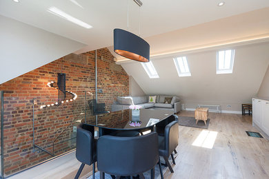 This is an example of a mid-sized eclectic open plan dining in London with white walls and light hardwood floors.