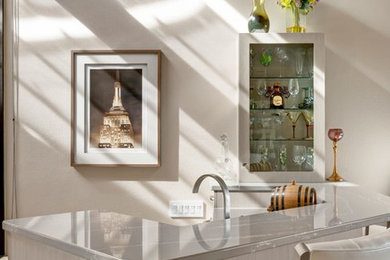 Home bar - small transitional ceramic tile and beige floor home bar idea in Los Angeles with a drop-in sink, flat-panel cabinets, gray cabinets, quartzite countertops and gray countertops